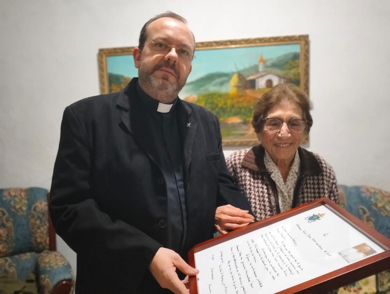 Juanita y su párroco muestran la carta del Papa Francisco a la catequista de 97 años