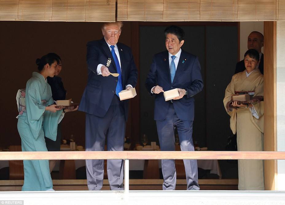 Donald Trump y el Primer Ministro de Japón, Shinzo Abe, dan de comer a los peces