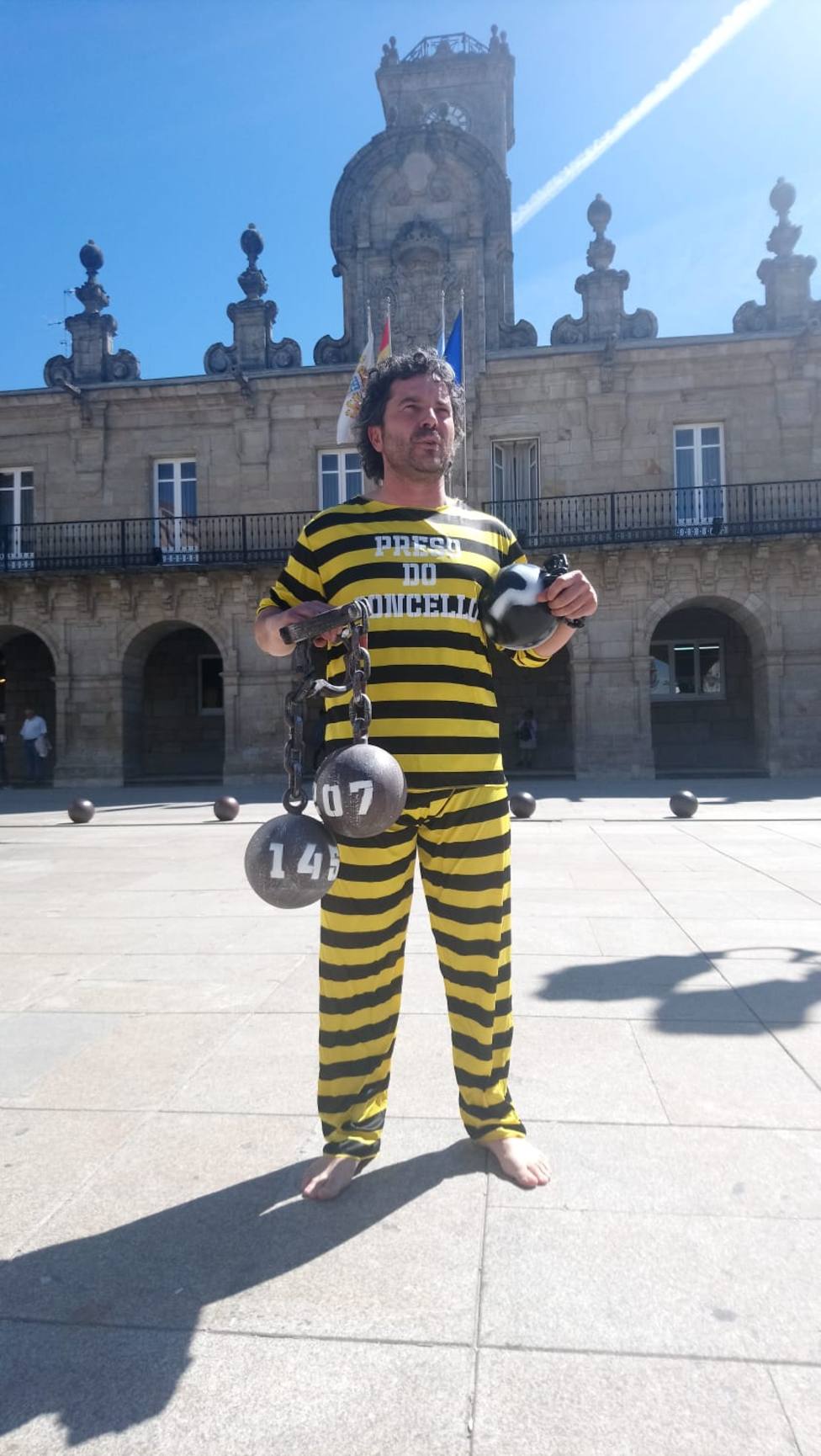 El propietario de una librería protesta con cadenas y vestido de preso por impagos del Concello