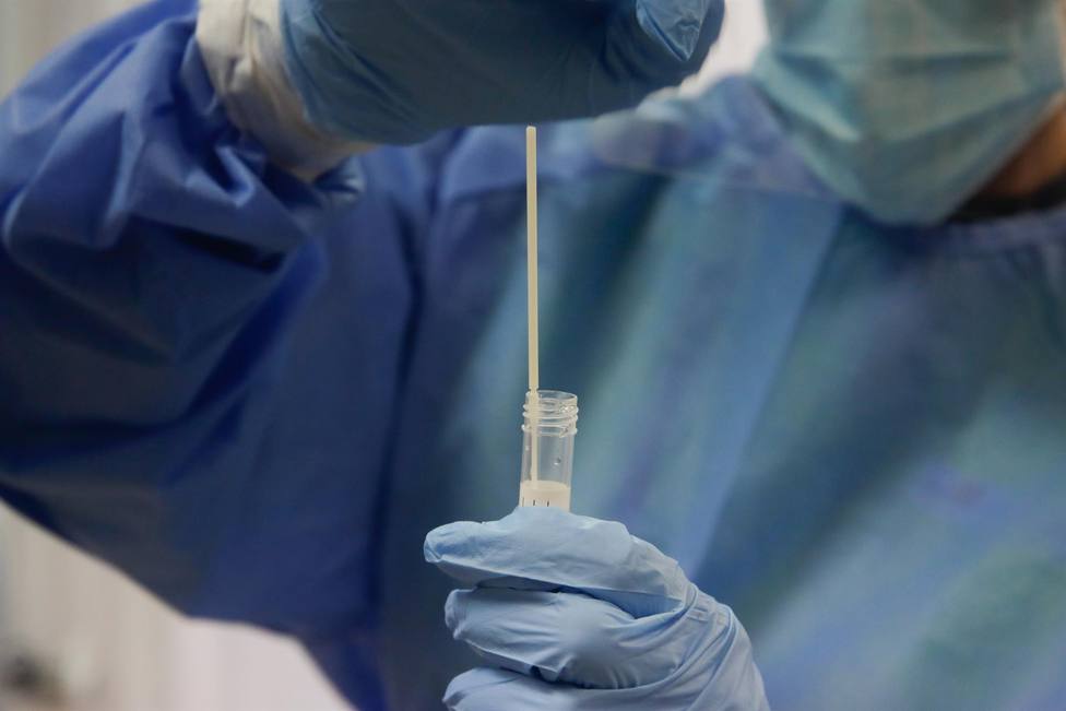 Una trabajadora sanitaria sostiene una probeta con una prueba PCR en el dispositivo instalado en el Centro de