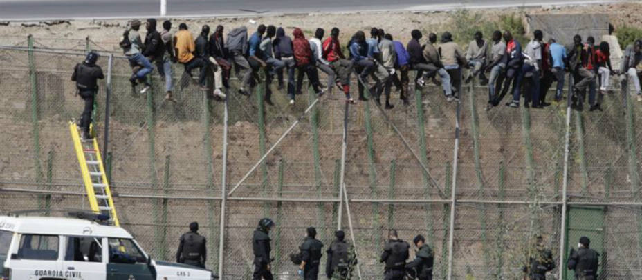 Subsaharianos encaramados a la valla de Melilla este miércoles. EFE