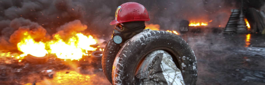 Un hombre se protege con un neumático (Reuters)