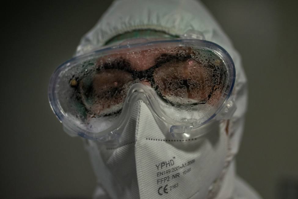 Un sanitario muestras su cara de cansancio tras atender una zona de afectados por coronavirus