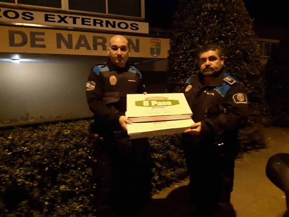 Dos agentes con algunas de las pizzas entregadas por el establecimiento de Narón - FOTO: Cedida