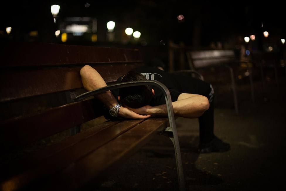 Un hombre duerme sobre un banco en la Plaza de Catalunya, a 10 de junio de 2021, en Barcelona, Catalunya (Espa