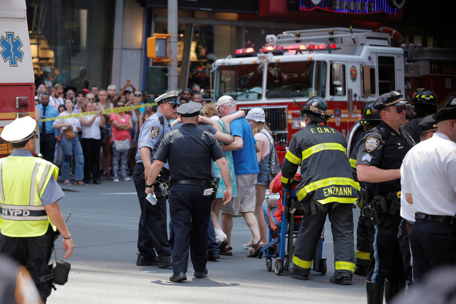First responders tend to injured pedestrians after a vehicle struck pedestrians on a sidewalk in Times Square in New York