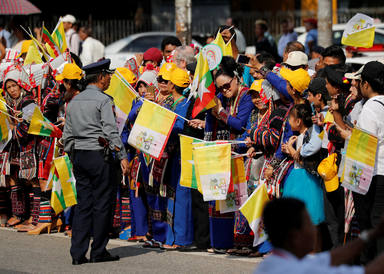 People line the street as they await the arrival of Pope Francis in Yangon