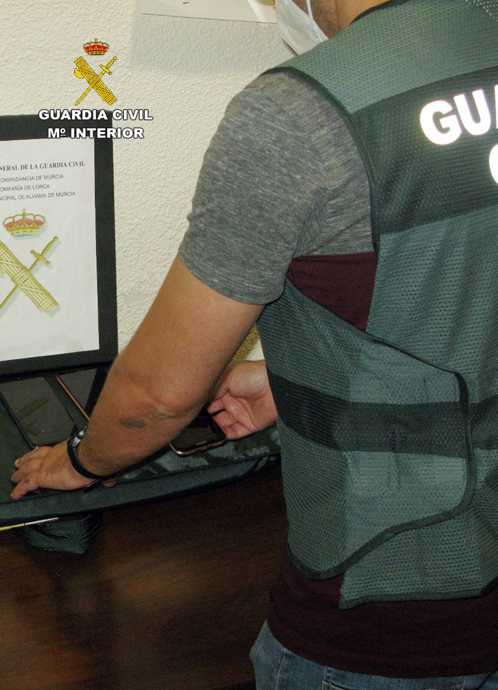 Un agente de la Guardia Civil muestra mÃ³viles recuperados en la operaciÃ³n