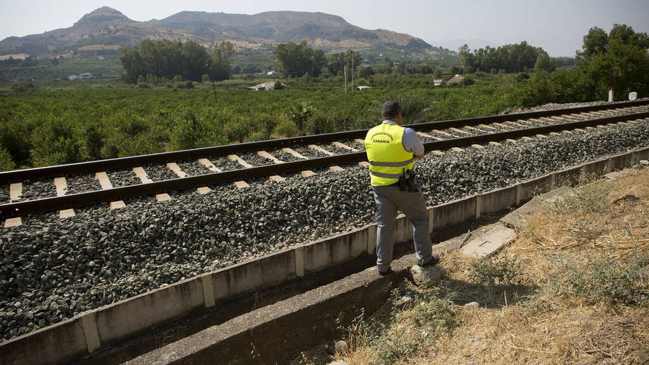 Un vigilante de seguridad ante la vía férrea donde falleció la menor de 3 años Lucía Vivar Hidalgo, desaparecida en Pizarra (Málaga)