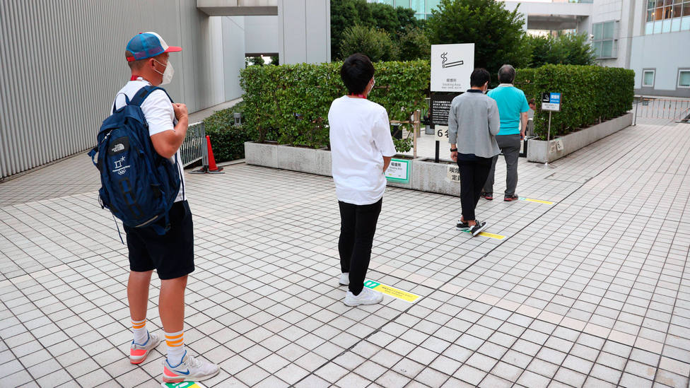 Japoneses guardan distancia de seguridad para un área de fumadores. CORDONPRESS