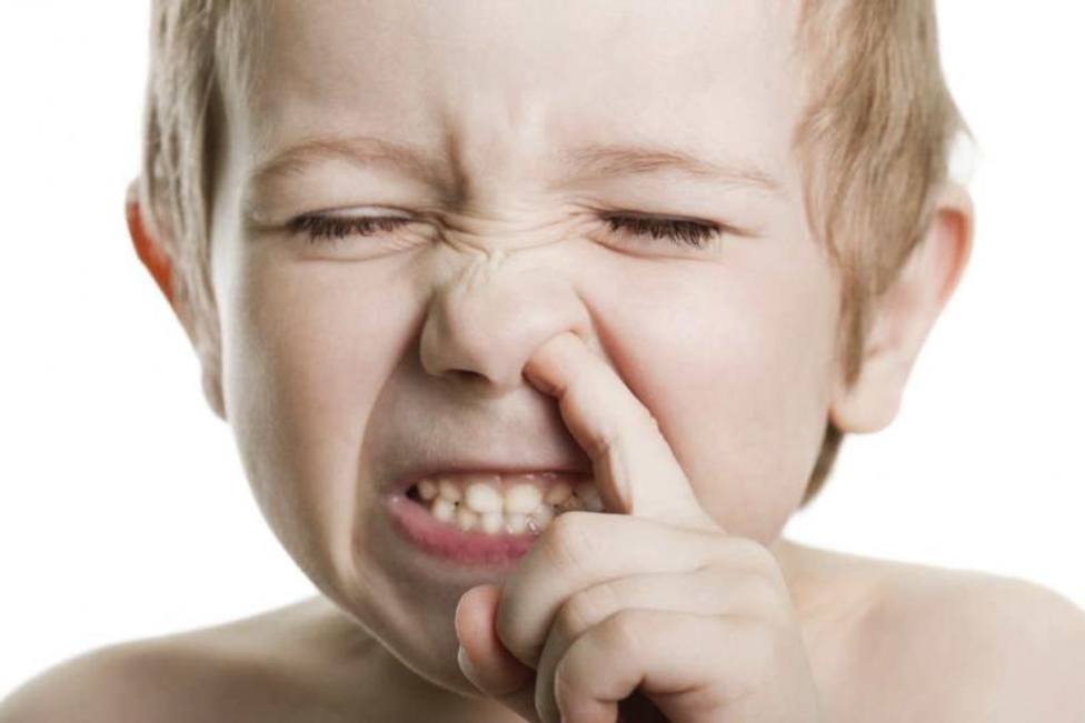 Una imagen de archivo de un niño sacándose un moco de la nariz
