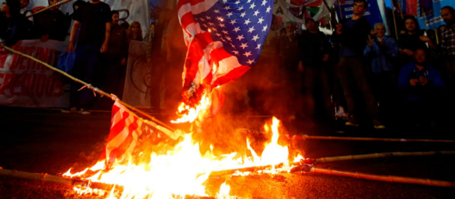 Imagen de archivo de varios trabajadores quemando banderas estadounidenses.
