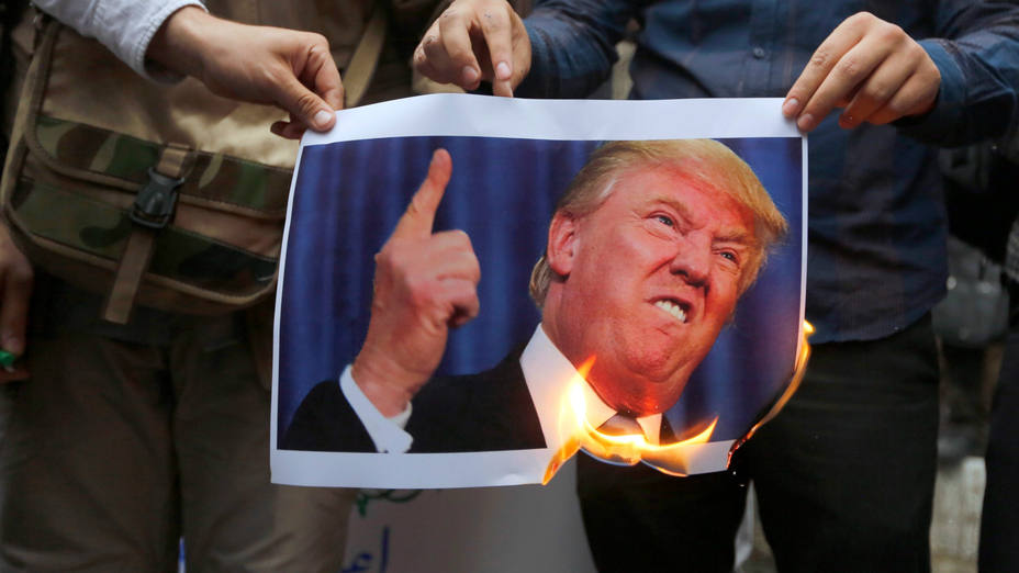 Un grupo de iraníes quema una fotografía del presidente estadounidense, Donald Trump