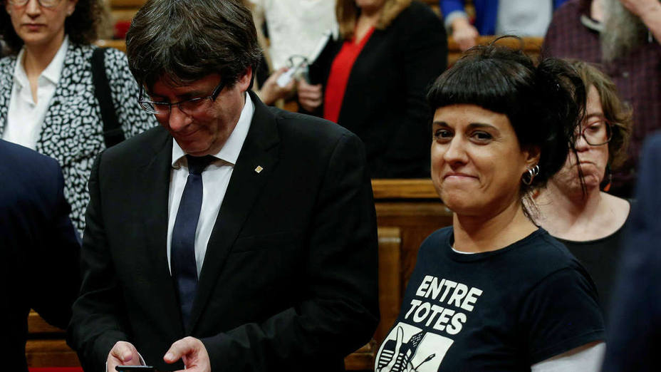FILE PHOTO: Leftist CUP party member Gabriel walks past Catalan President Puigdemont during a debate in the Catalan regional parliament in Barcelona