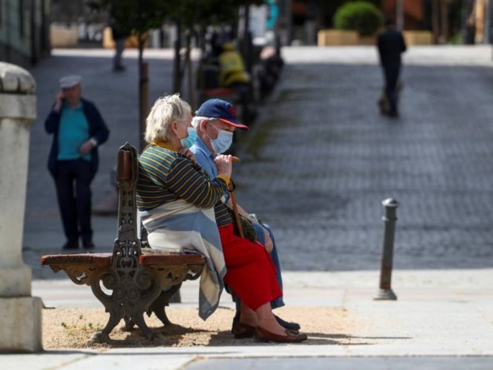 FOTO DE ARCHIVO: Personas mayores con mascarilla en un banco de un parque en Madrid, EspaÃ±a