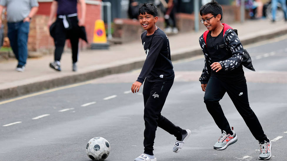 Dos niños juegan en la calle con un balón de fútbol. CORDONPRESS