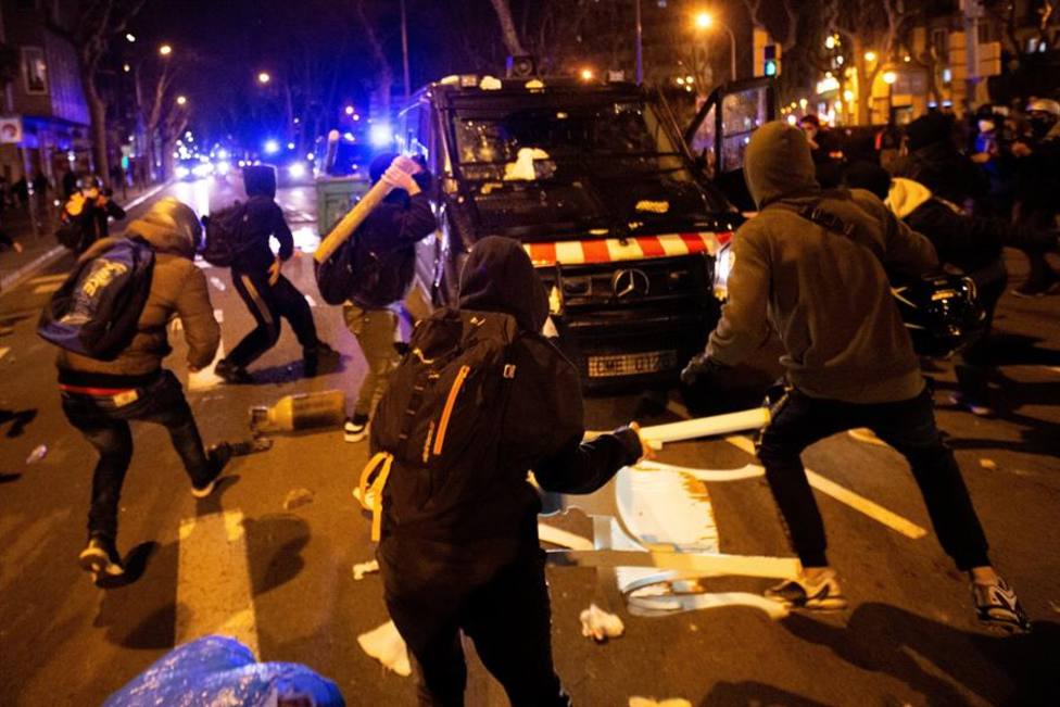 manifestantes lanzan objetos a un vehículo de los cuerpos antidisturbios
