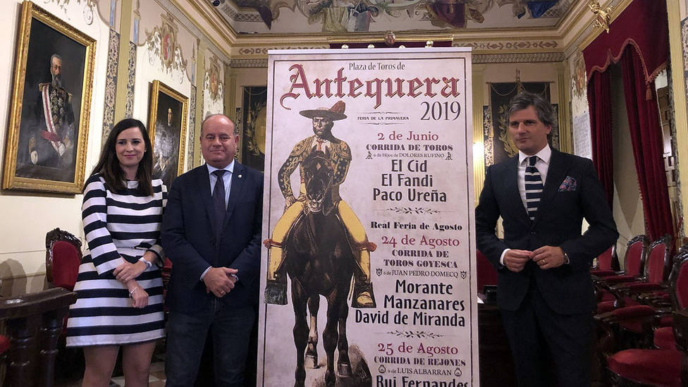 Ana Cebrián, Manuel Jesús Barón y Jorge Buendía junto a los carteles de la temporada taurina de Antequera