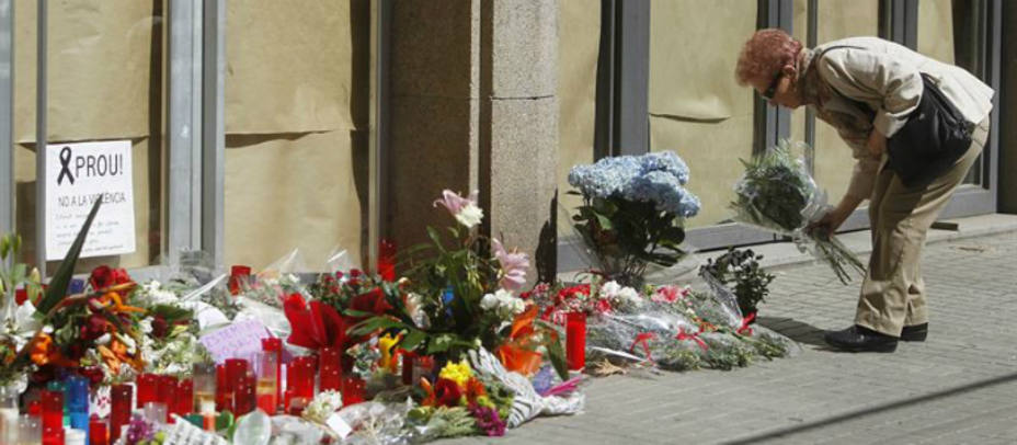 Una mujer deposita flores a las puertas del instituto Joan Fuster de Barcelona. EFE