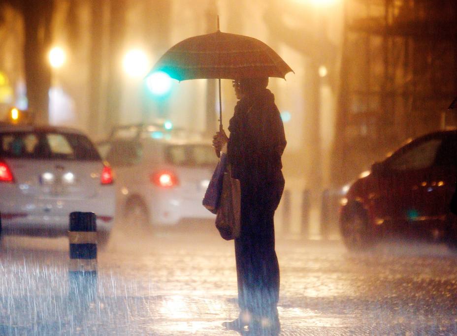 Señora bajo la lluvia en Valencia en 2012