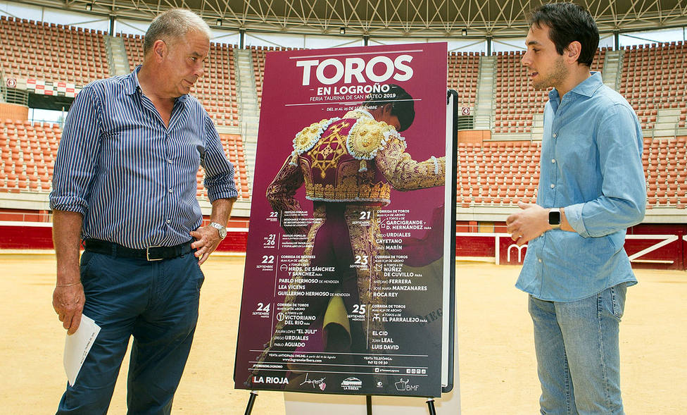 Óscar Chopera y su sobrino Manuel junto al cartel anunciador de la Feria de San Mateo de Logroño