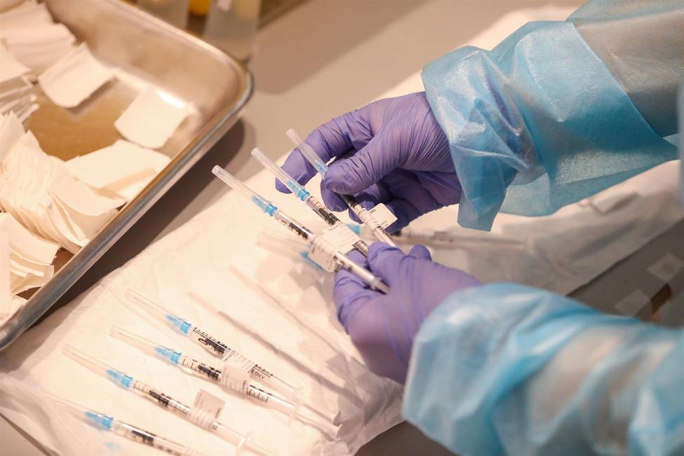 Un empleado sanitario sostiene una de las vacunas de Pfizer contra el Covid-19