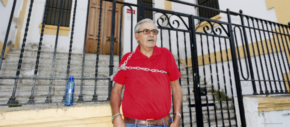 Francisco Gómez encadenado en la verja exterior de la sede local socialista de Mérida. EFE