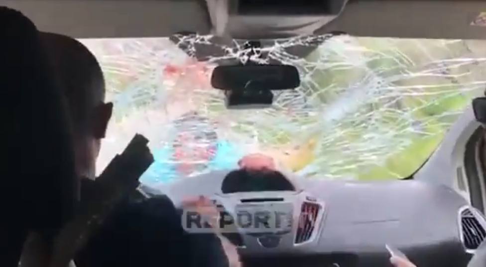 El dueño de un restaurante en Albania se cuelga del parabrisas del coche de unos turistas españoles