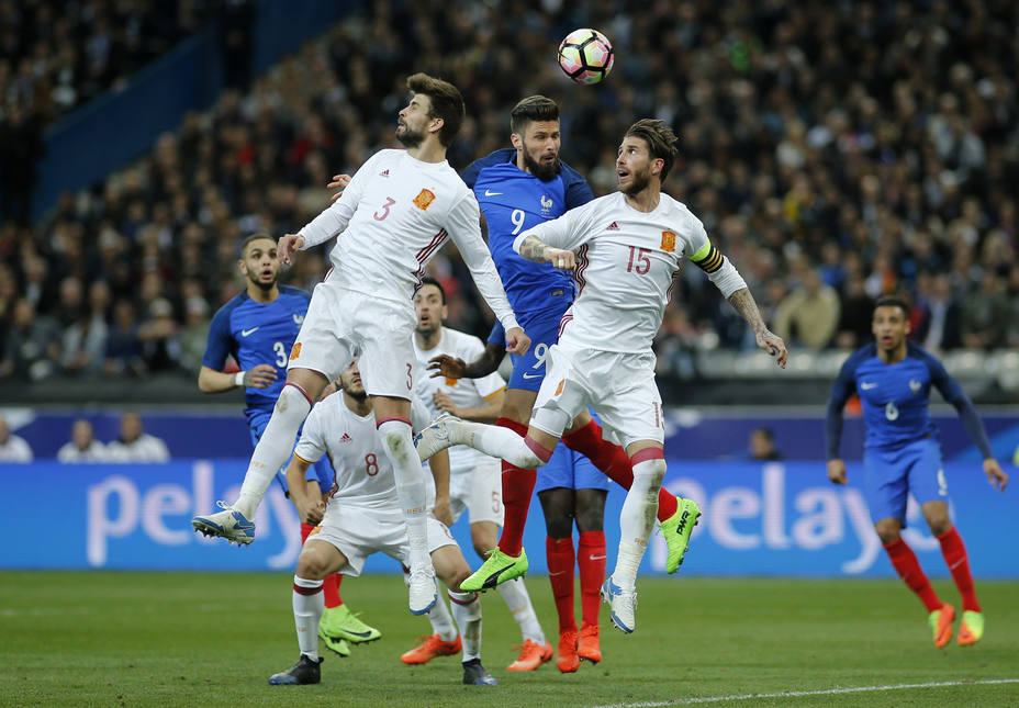 Frances Olivier Giroud heads at goal as Spains Sergio Ramos and Gerard Pique defend