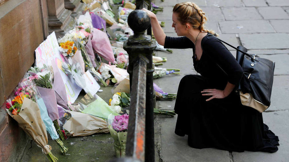 A woman lays flowers for the victims of the Manchester Arena attack, in central Manchester