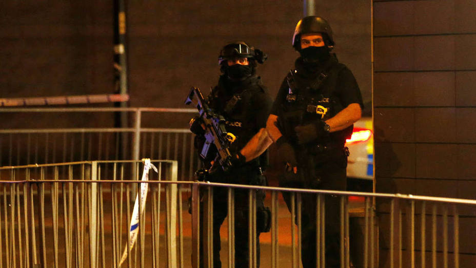 Armed police officers stand next to a police cordon outside the Manchester Arena, where U.S. singer Ariana Grande had been performing, in Manchester, northern England, Britain