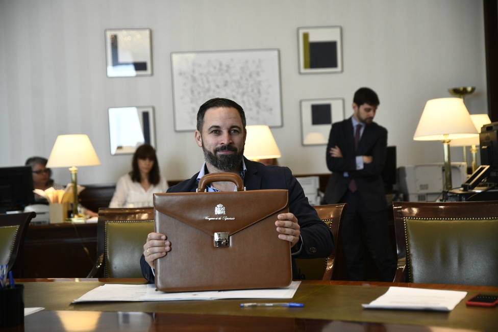 El presidente de VOX, Santiago Abascal, sujeta su cartera de diputado en el Congreso de los Diputados tras entregar sus credenciales.