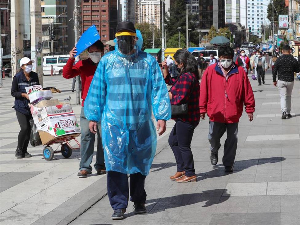 Un hombre camina con una bolsa, tapabocas y careta como medida de protección contra el coronavirus, en Bolivia