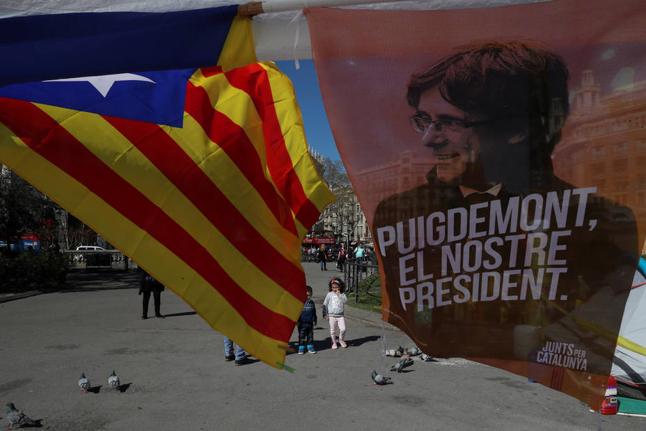 Una Estelada junto a una cartel con la imagen de Puigdemont