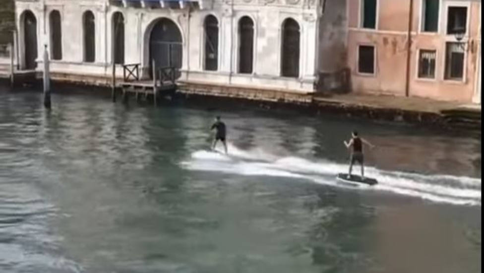 Dos jóvenes hacen esquí acuático en el Gran Canal de Venecia