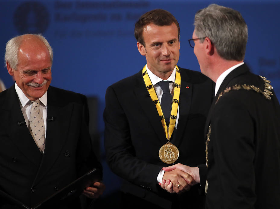 El presidente francés Emmanuel Macron posa con el Premio Carlomagno junto a Marcel Philipp (R), alcalde de Aachen y Juergen Linden, presidente del consejo de administración del premio durante una ceremonia en Aquisgrán