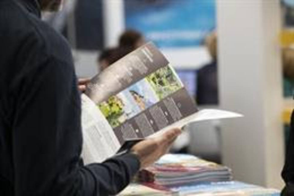 Una persona lee un folleto en el B-Travel