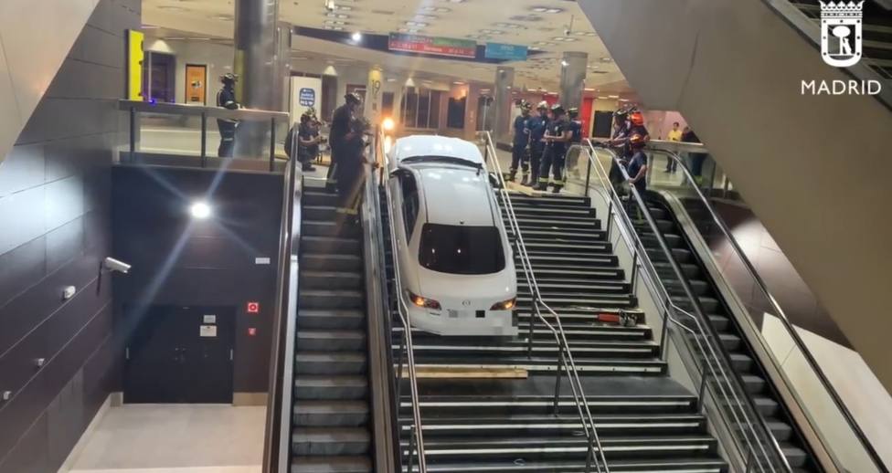 Bomberos del Ayuntamiento de Madrid retiran el coche encajado en las escaleras del intercambiador de Plaza ElÃ­ptica.