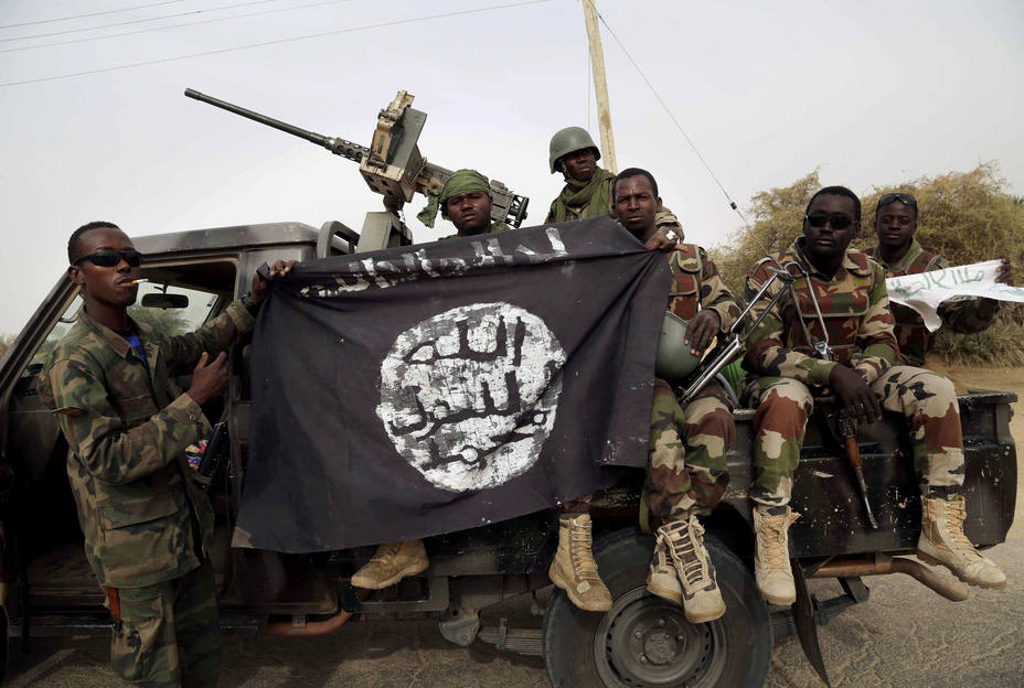 Soldados nigerianos sostienen una bandera de Boko Haram que habían capturado en la ciudad recientemente recuperada de Damasak