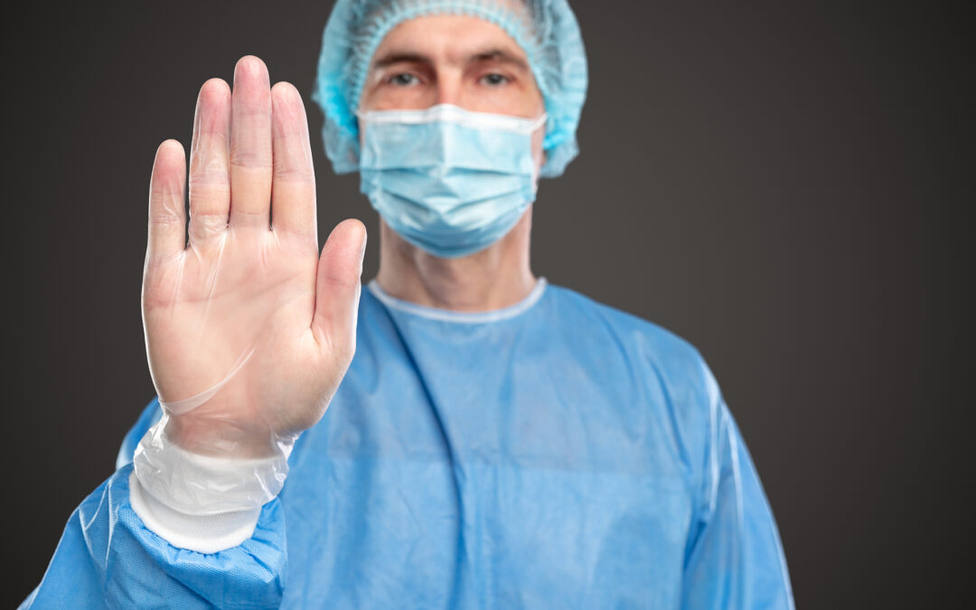 Male doctor gesturing stop to virus