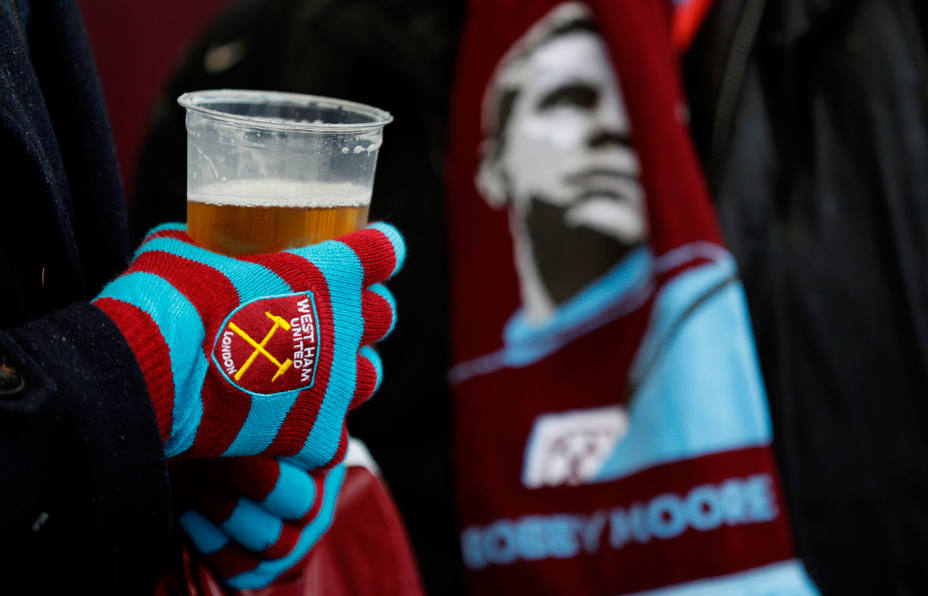 Un aficionado al fútbol sujeta un vaso de cerveza. REUTERS