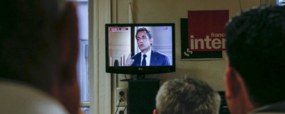 Miembros de la coalición conservadora francesa viendo la intervención televisiva de Nicolas Sarkozy. REUTERS