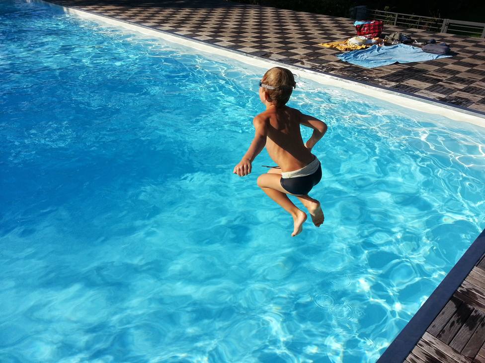 Foto de un niño lanzándose a una piscina