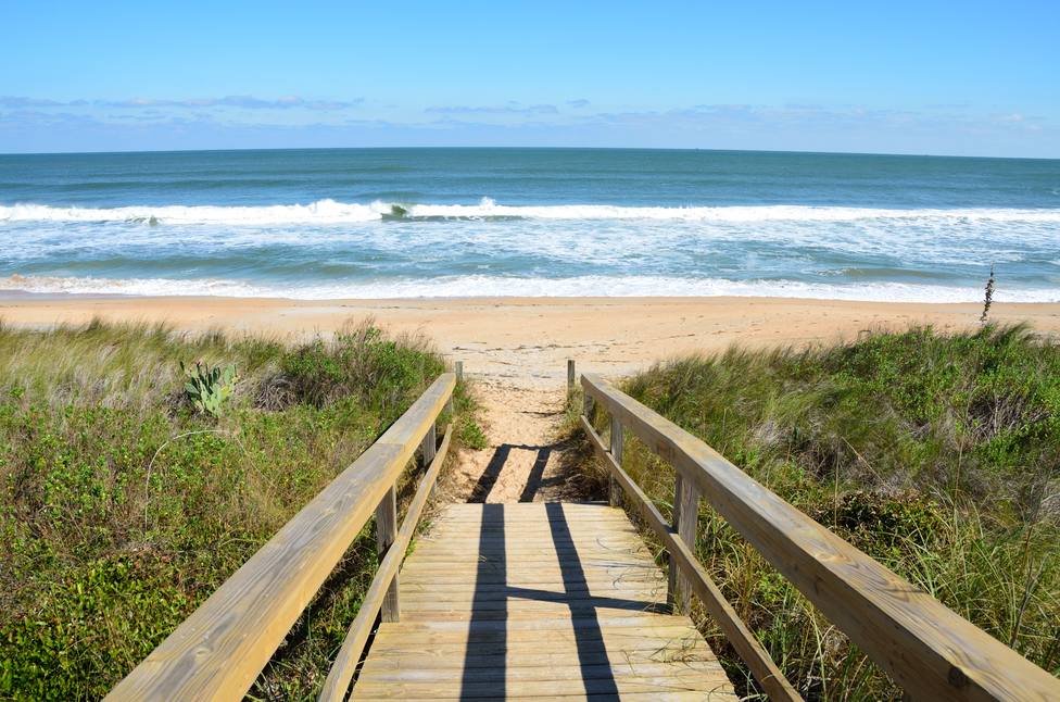 Foto de archivo de una pasarela de madera en una playa
