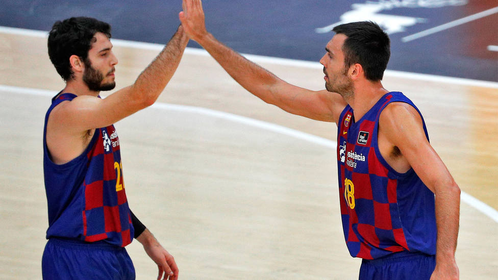 Los jugadores del Barça, Álex Abrines y Pierre Oriola chocan la mano durante el partido. EFE