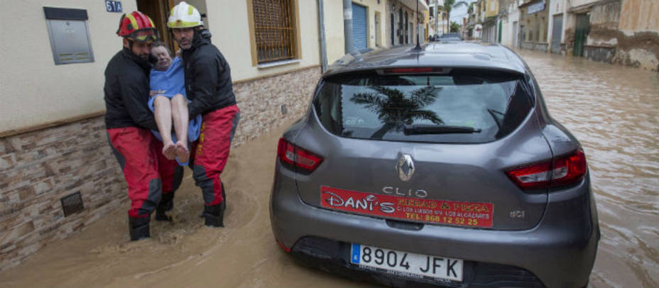 Los mimebros de la UME ayudando a personas a abandonar sus casas anegadas por la riada. EFE
