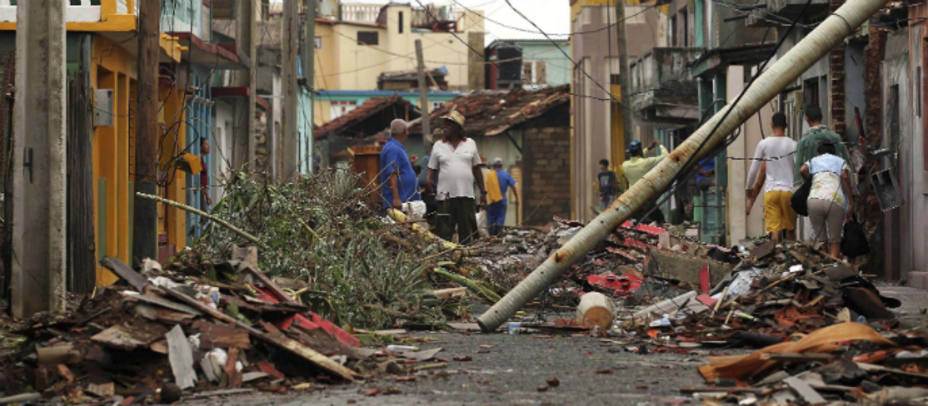 Cubanos caminan entre los escombros este jueves, en Baracoa (Cuba), dos días después del paso del huracán Matthew. EFE