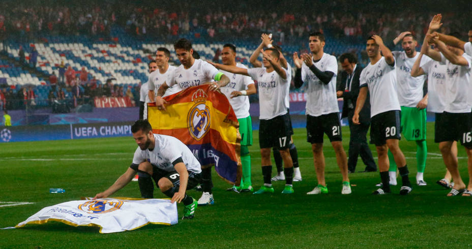 Nacho extiende una bandera del Real Madrid sobre el césped del Vicente Calderón. REUTERS
