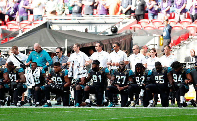 Jugadores de la NFL se arrodillan durante la ejecución del himno de EEUU como protesta. REUTERS