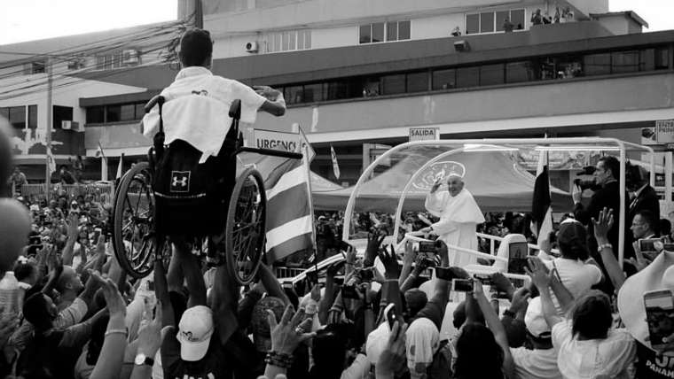 Un grupo de jóvenes de la JMJ levantan a un chico en silla de ruedas y el Papa le bendice